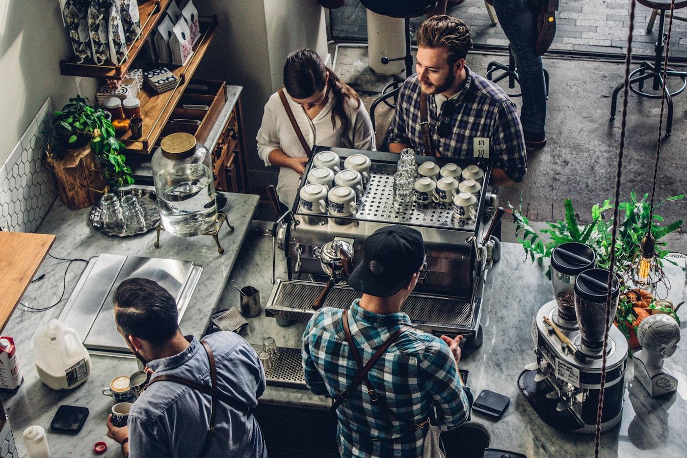 Small business owner working at a shop counter with a customer